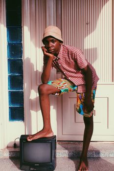 Teen fashion portrait with colorful attire and retro TV in urban setting