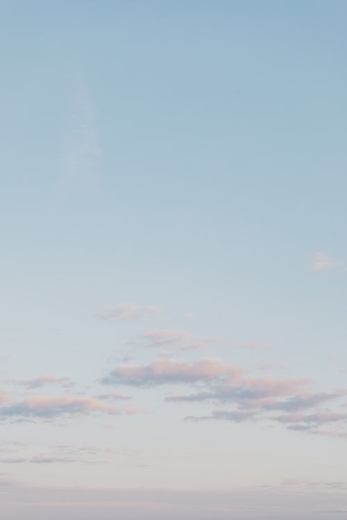 Free Pastel blue sky with gentle clouds creating a serene atmosphere. Ideal for backgrounds. Stock Photo