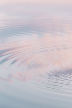 日落时分，柔和的天空倒映在宁静的海面涟漪中，营造出安详的景象