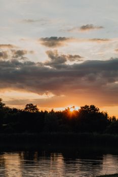 宁静的日落时分，云层倒映在平静的湖面上，构成了一幅宁静的自然景观