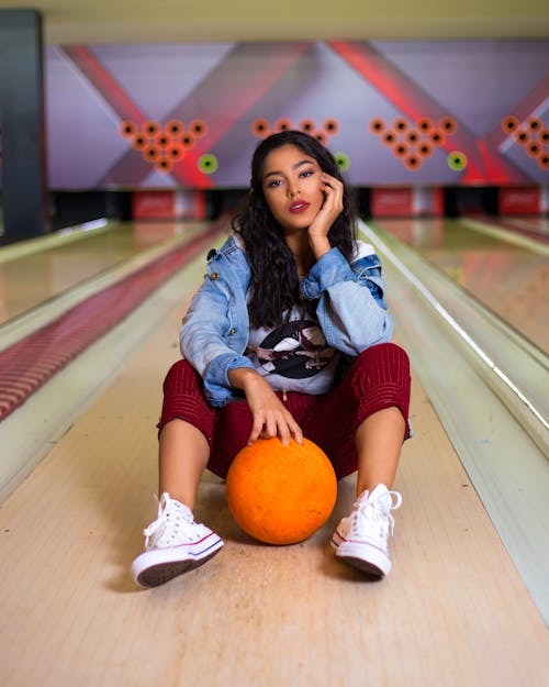 Beautiful Woman Sitting on a Bowling Alley Floor 