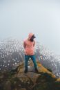 Unrecognizable traveler on mount behind birds in mist
