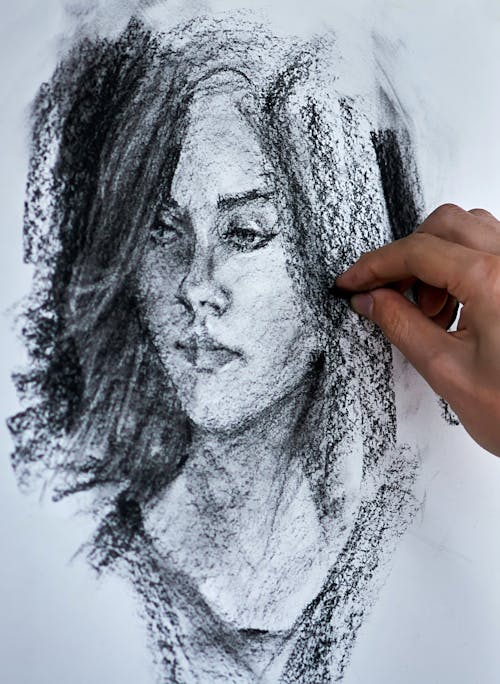 Artist drawing portrait with pencil on paper