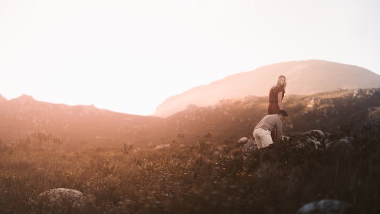 Couple Walking On Grass Field