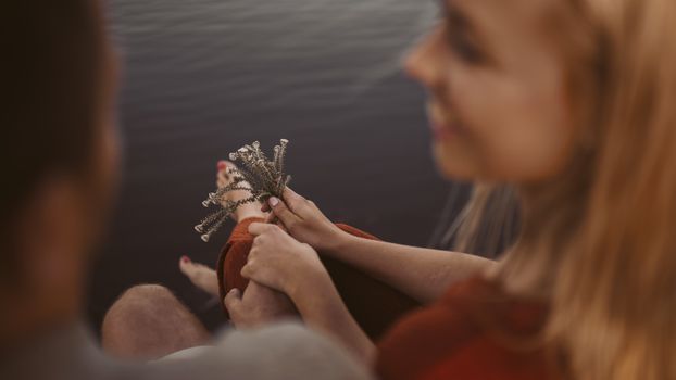 一对夫妇在湖边拿着野花，享受着温柔的时刻