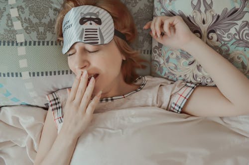 Free Sleepy woman yawning on bed Stock Photo