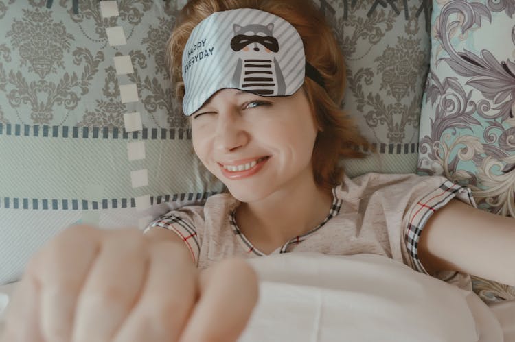 Smiling Woman With Sleep Mask In Bedroom