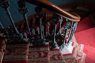 华丽的复古楼梯特写，配有红地毯和铸铁栏杆