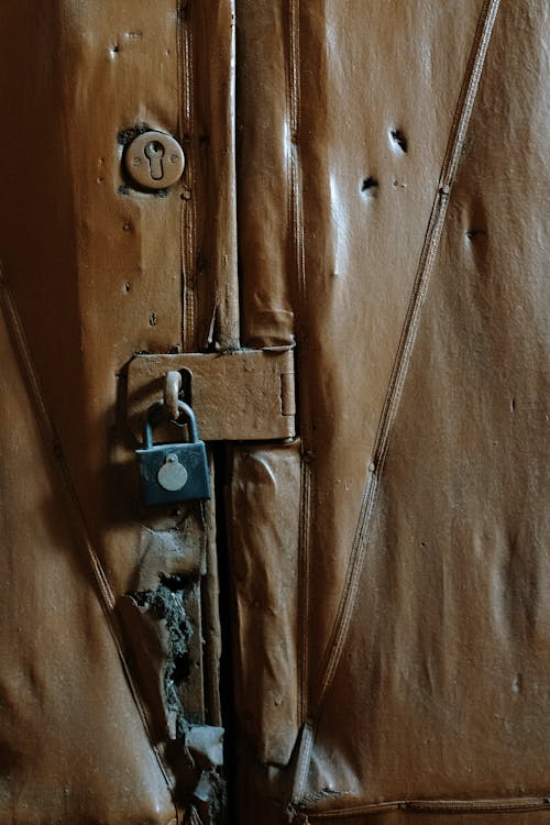 銀の南京錠が付いている茶色の木製のドア
