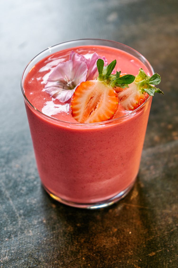 Smoothie Decorated With Strawberry Slices And Flowers