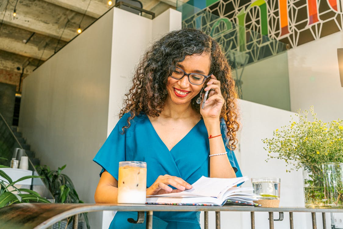 smiling-woman-talking-on-phone-in-cafe