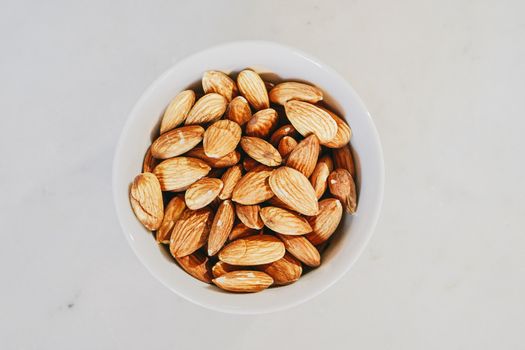 特写镜头中，白碗里的生杏仁突出了其质地和自然的吸引力