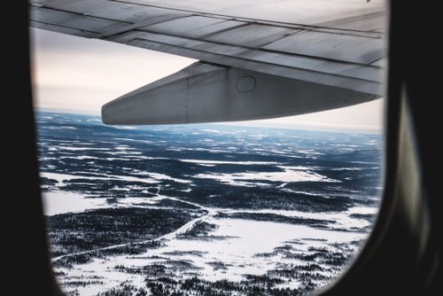 Free Snowy terrain seen from an airplane window during flight, showcasing vast wilderness. Stock Photo