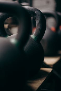 Detailed view of kettlebells lined up in a gym setting, capturing their rugged texture.