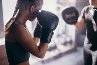一名女拳击手和她的教练正在健身房练习拳击技术