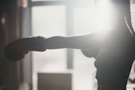 阳光下，女拳击手出拳的剪影捕捉了力量和焦点
