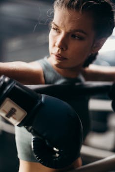 Young female boxer intensely training with gloves in a gym setting.