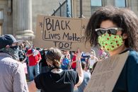 Unrecognizable people protesting on street with sign