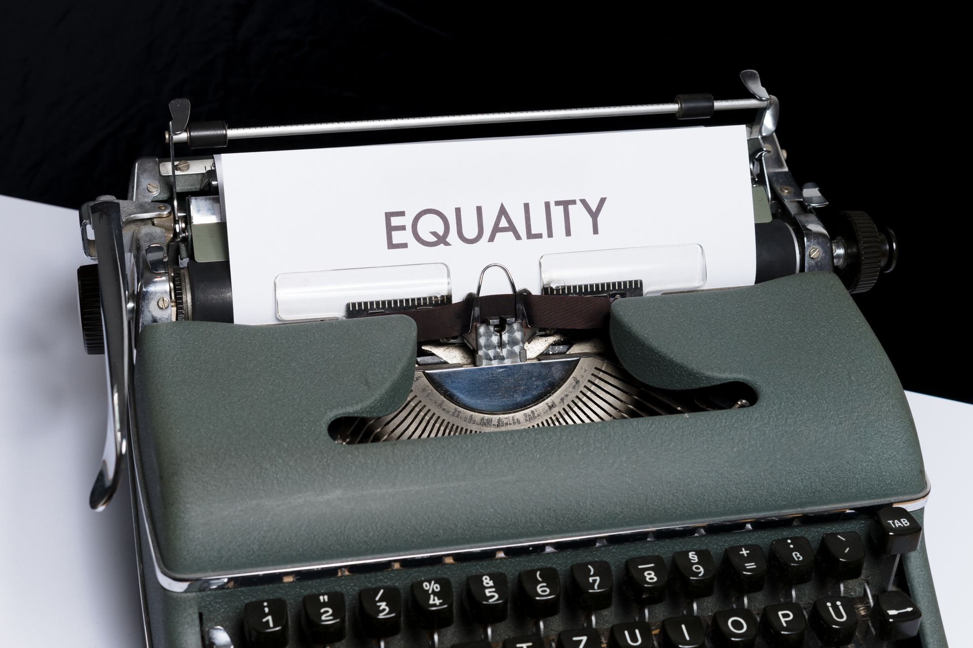Close-up of a vintage typewriter with the word 'Equality' typed on paper, symbolizing equality and inclusivity.