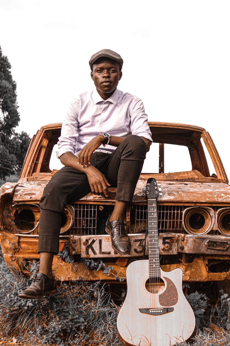 Man With Guitar On Car Wreckage