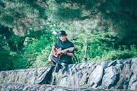 A Man Playing a Guitar Outdoors