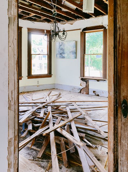 Free Interior room under renovation with exposed beams and planks piled on the floor. Stock Photo