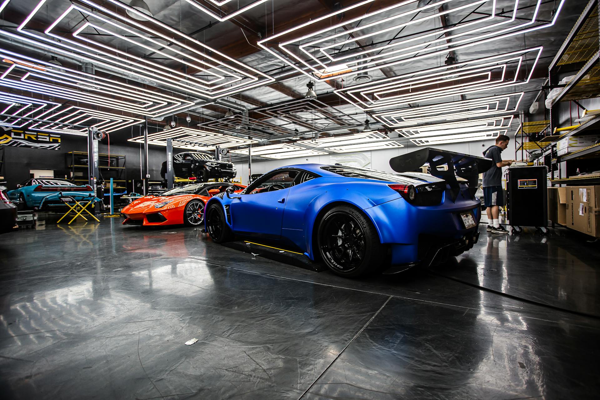 Sleek sports cars in a high-tech automotive workshop with a modern design.