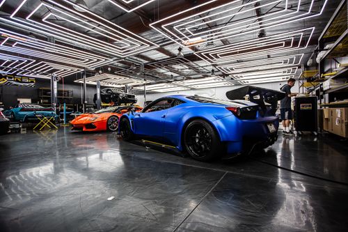 Free Sleek sports cars in a high-tech automotive workshop with a modern design. Stock Photo