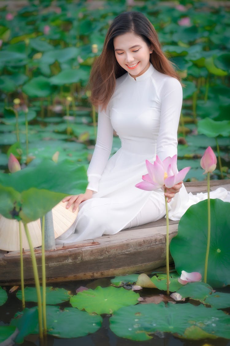 Woman On Boat In Bloomed Water Lilies