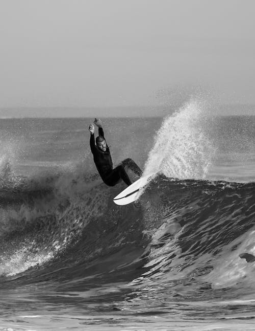 Grayscale Photo of a Man Surfing