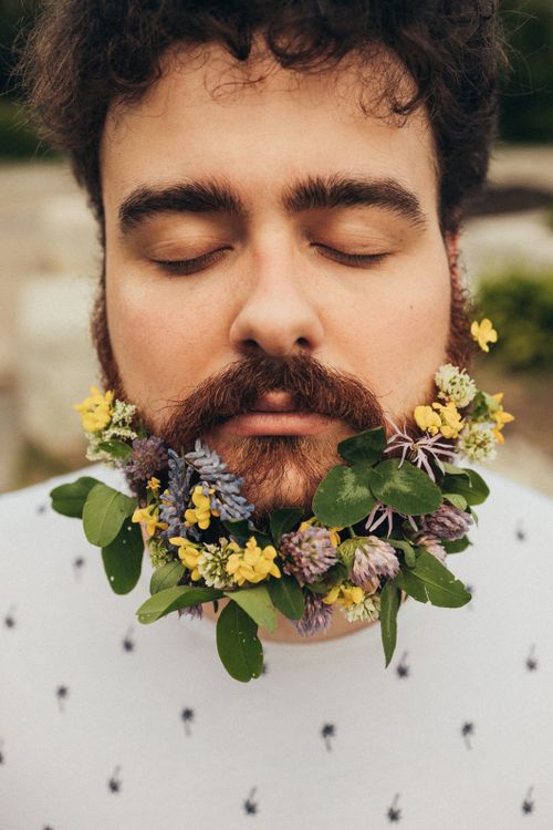 Free Close-up portrait of a man with a floral beard, eyes closed, conveying tranquility. Stock Photo