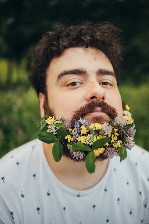 Free Creative portrait of a man with a colorful floral beard, merging nature with style. Stock Photo