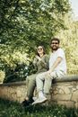 Man and Woman Sitting on Concrete Bench