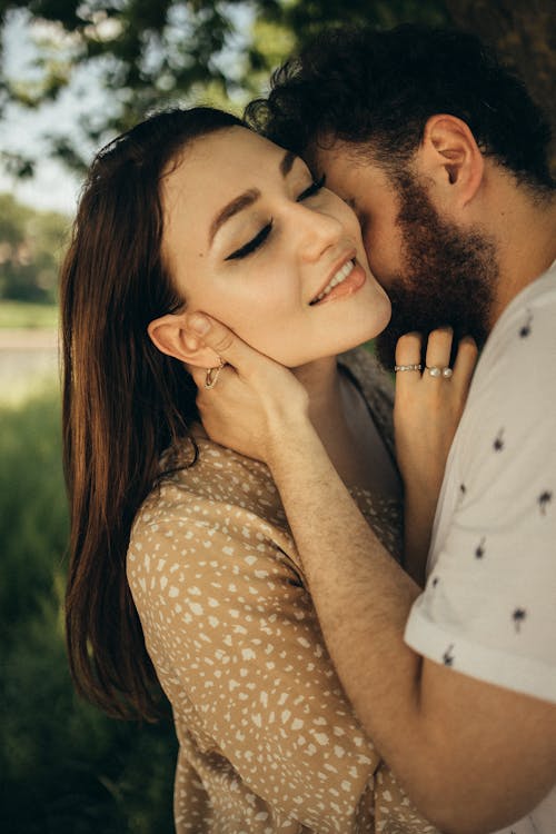Close Up Photo of a Man Kissing a Woman