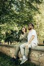 Man and Woman Sitting on Concrete Bench