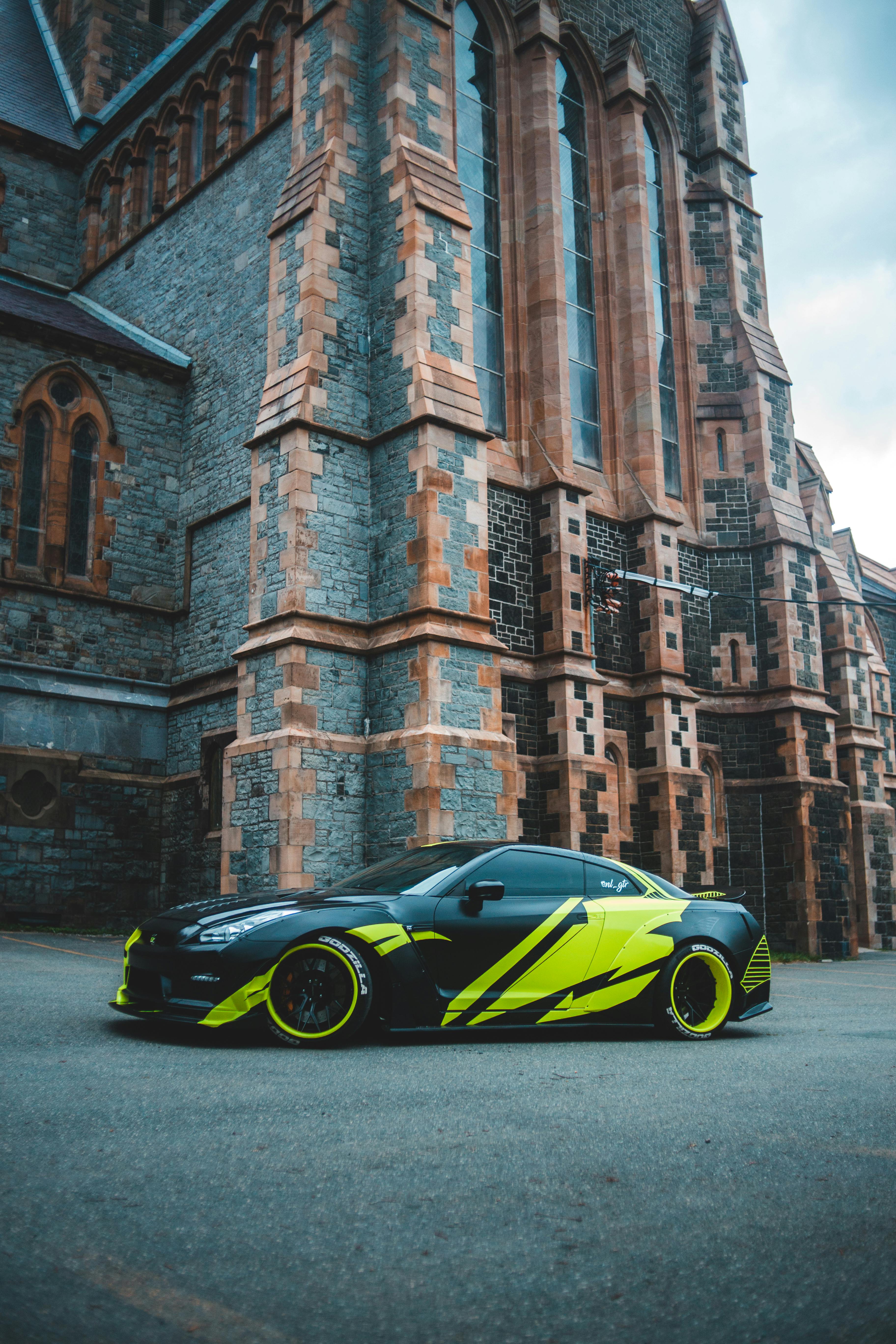 Luxury car near old brick building · Free Stock Photo