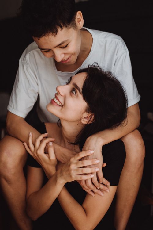 Free Candid portrait of a happy couple embracing and sharing affectionate smiles. Stock Photo