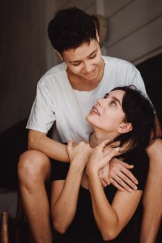 一对夫妇在室内微笑着拥抱，表达爱意的温馨肖像
