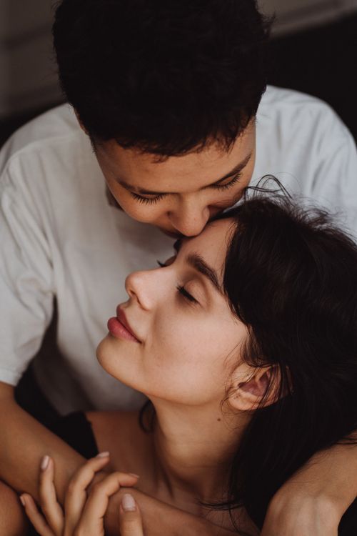 Free Tender and intimate moment between a loving same-sex couple sharing a soft kiss on the forehead. Stock Photo