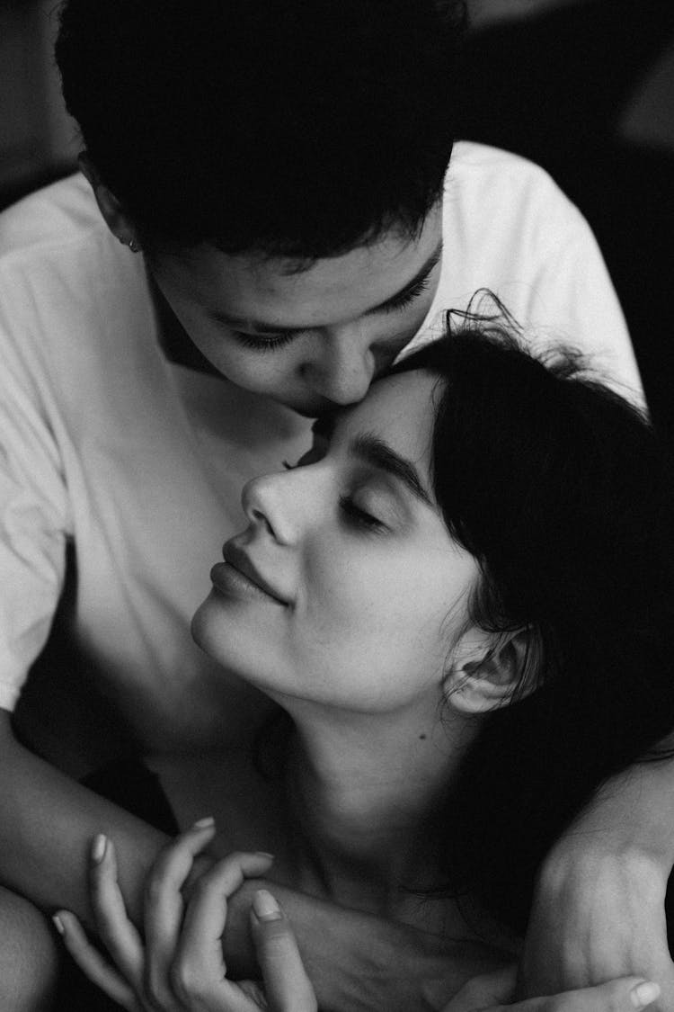 Black And White Portrait Of Woman Kissing Girlfriend On Forehead