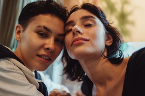 Free Two women smiling and embracing warmly, showcasing love and companionship indoors. Stock Photo