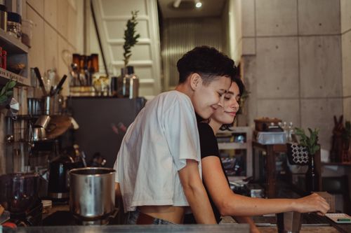 Free A joyful couple enjoying a warm moment together in a modern kitchen setting. Stock Photo