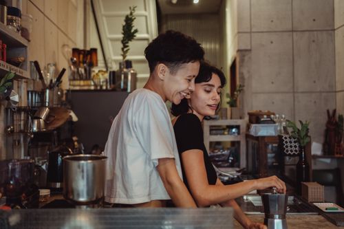 Free A happy couple enjoying their morning routine together in a stylish urban kitchen, embracing joyfully. Stock Photo