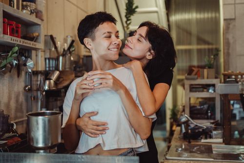 Free A joyful couple embracing in a modern kitchen, sharing a warm moment together. Stock Photo
