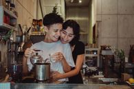 Shot of Two Brunettes Smiling While Using Kettle in a Kitchen
