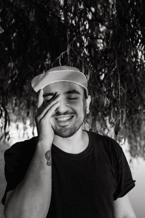 Free Monochrome photo of a smiling man outdoors, hand on face. Stock Photo