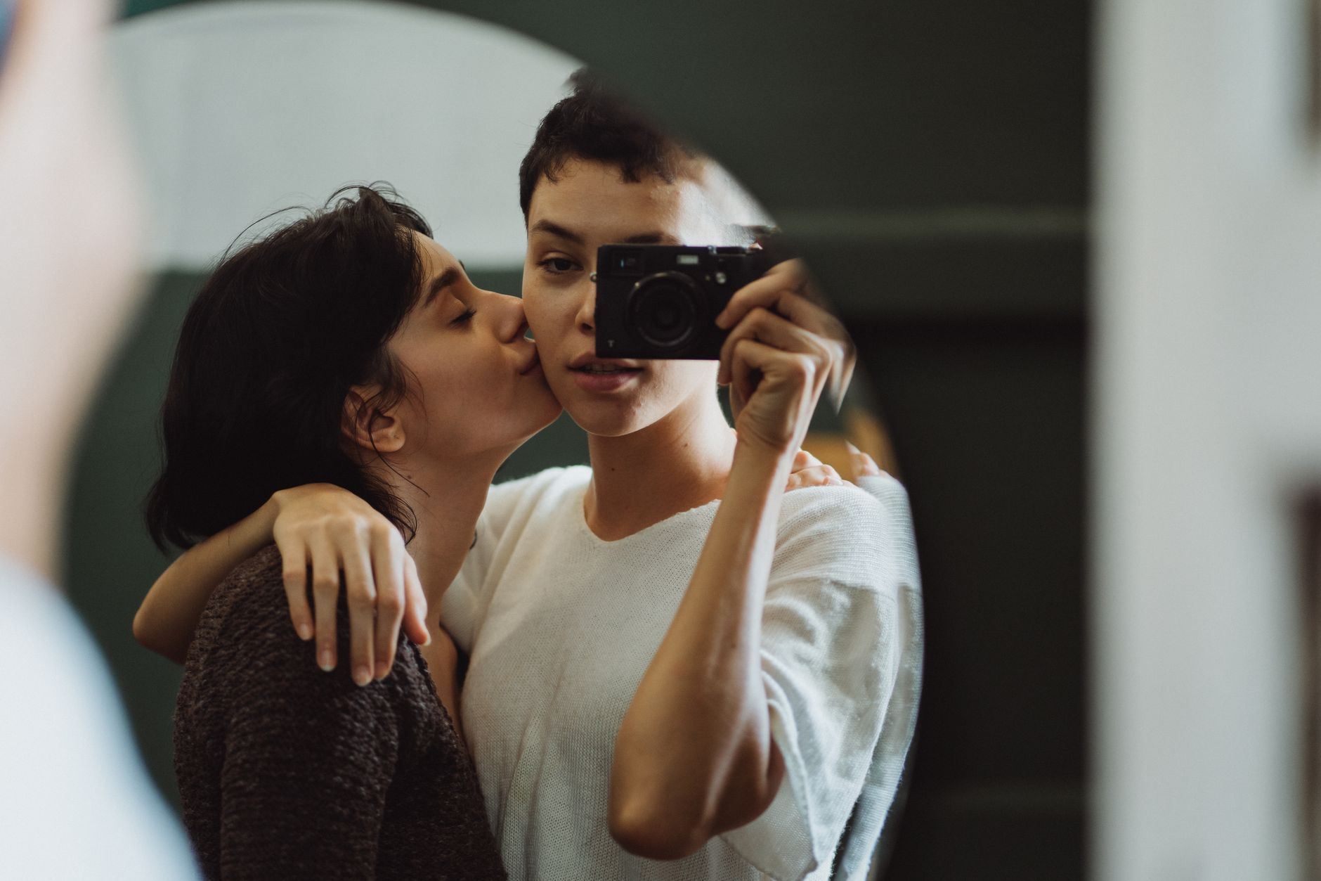 A close and loving moment captured between a couple using a mirror selfie.