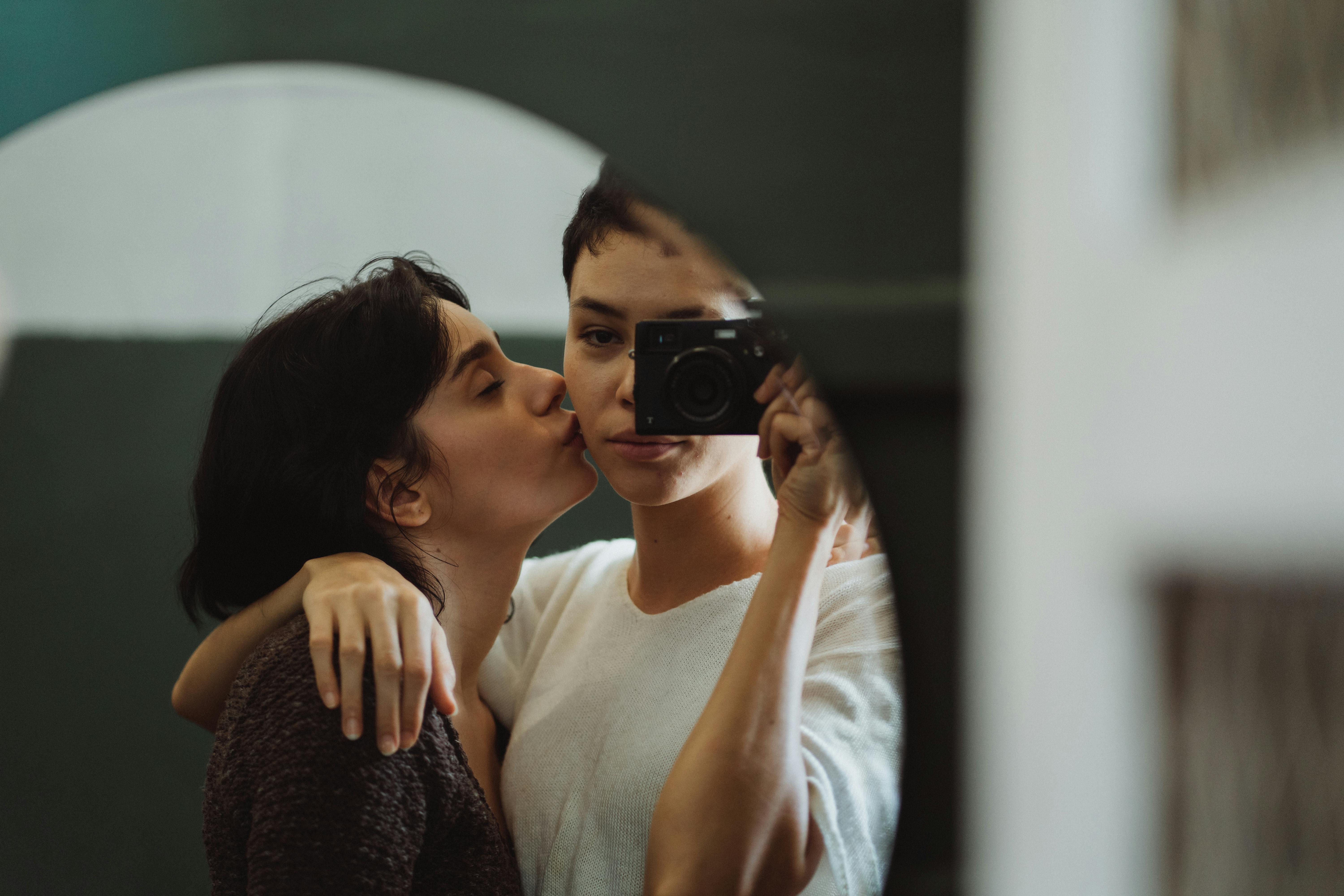 woman kissing another woman on the cheek