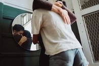 室内圆镜中，倒映出两人充满爱意的拥抱