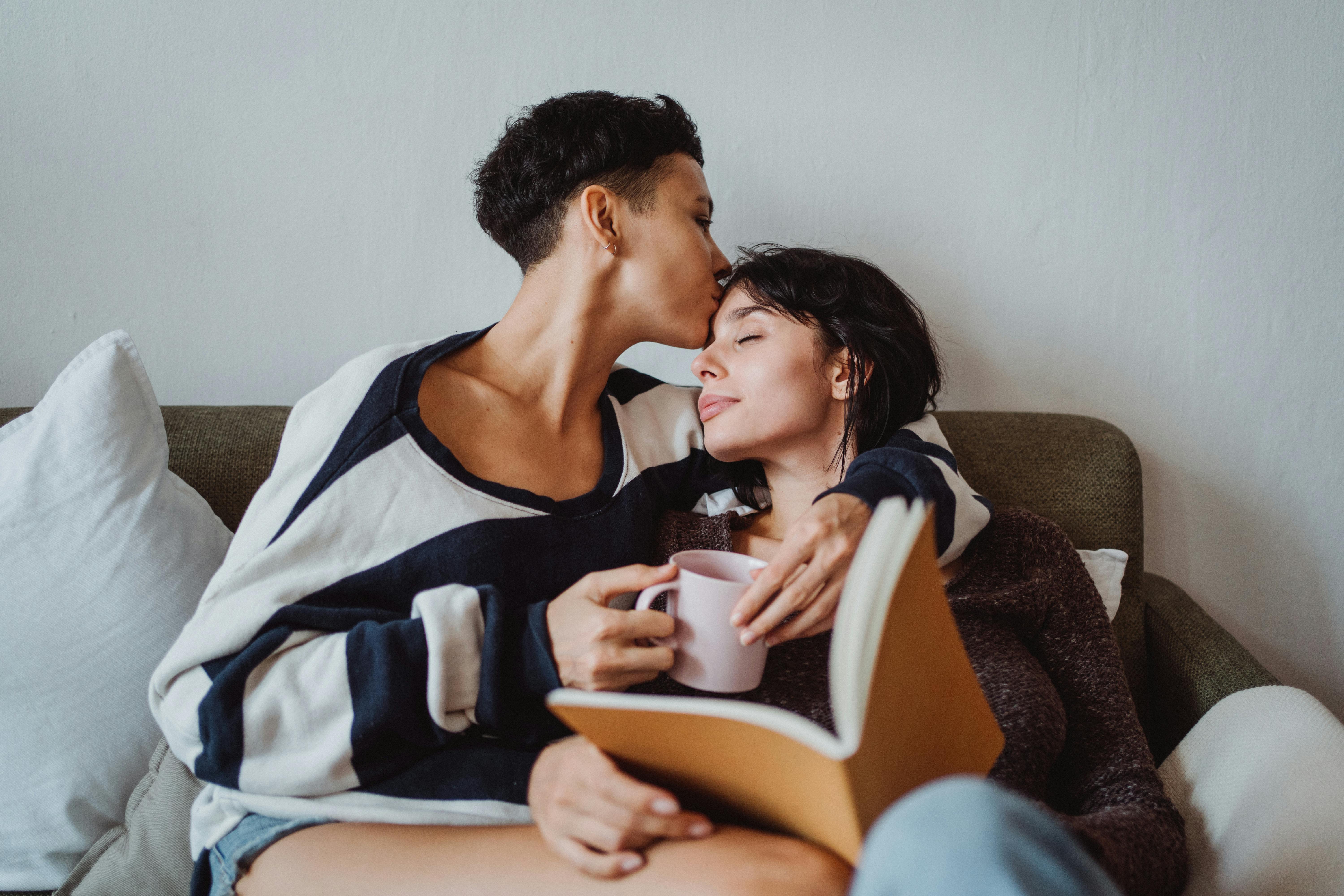 Woman Lying in Bed and Reading a Book and Her Girlfriend Kissing Her on the  Forehead · Free Stock Photo